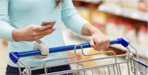 A WIC participant using the WICShopper app on her phone while grocery shopping