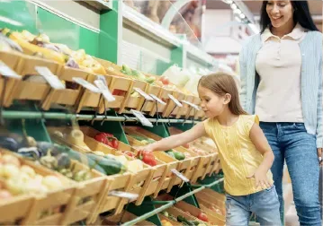 A mother and daughter shopping for fresh produce
