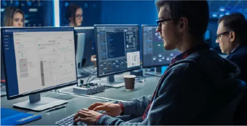 A NetApp engineer working at a multi-monitor development workstation